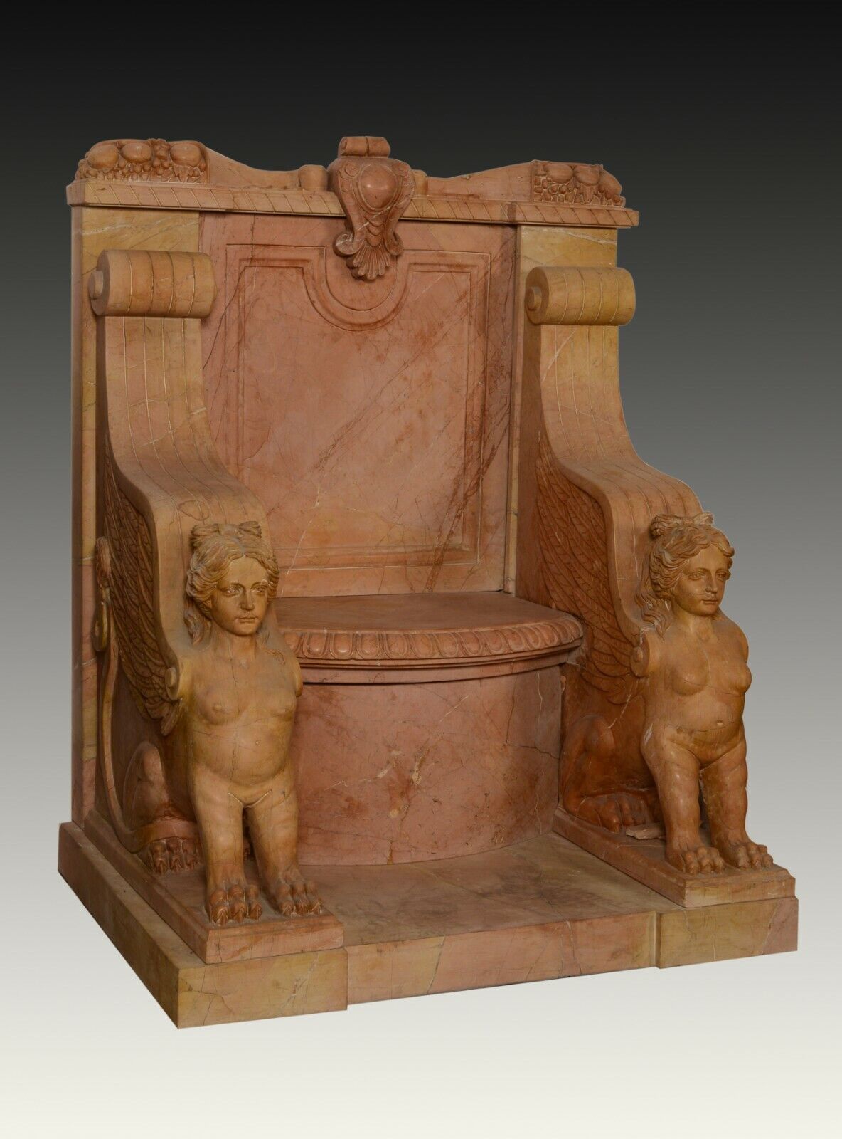 Carved red marble throne with two sphinxes. 